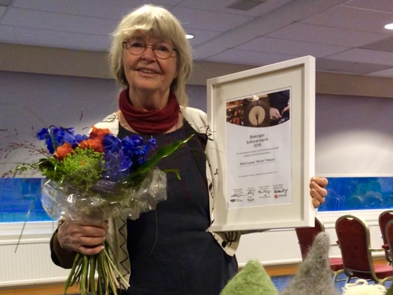 Bild på Mimmi Nilsson med diplom och blommor i handen.
