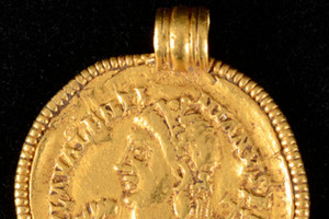 Närbild på guldmynt med hängögla