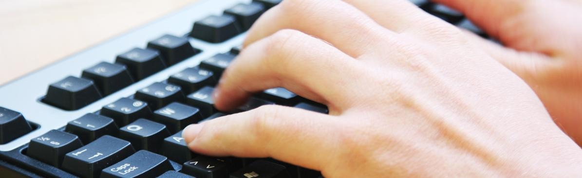 Närbild på ett tangentbord med fingrar som skriver